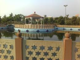 Couple enjoying candid pre-wedding shoot at Swarn Jayanti Park Ghaziabad with beautiful lake and gardens